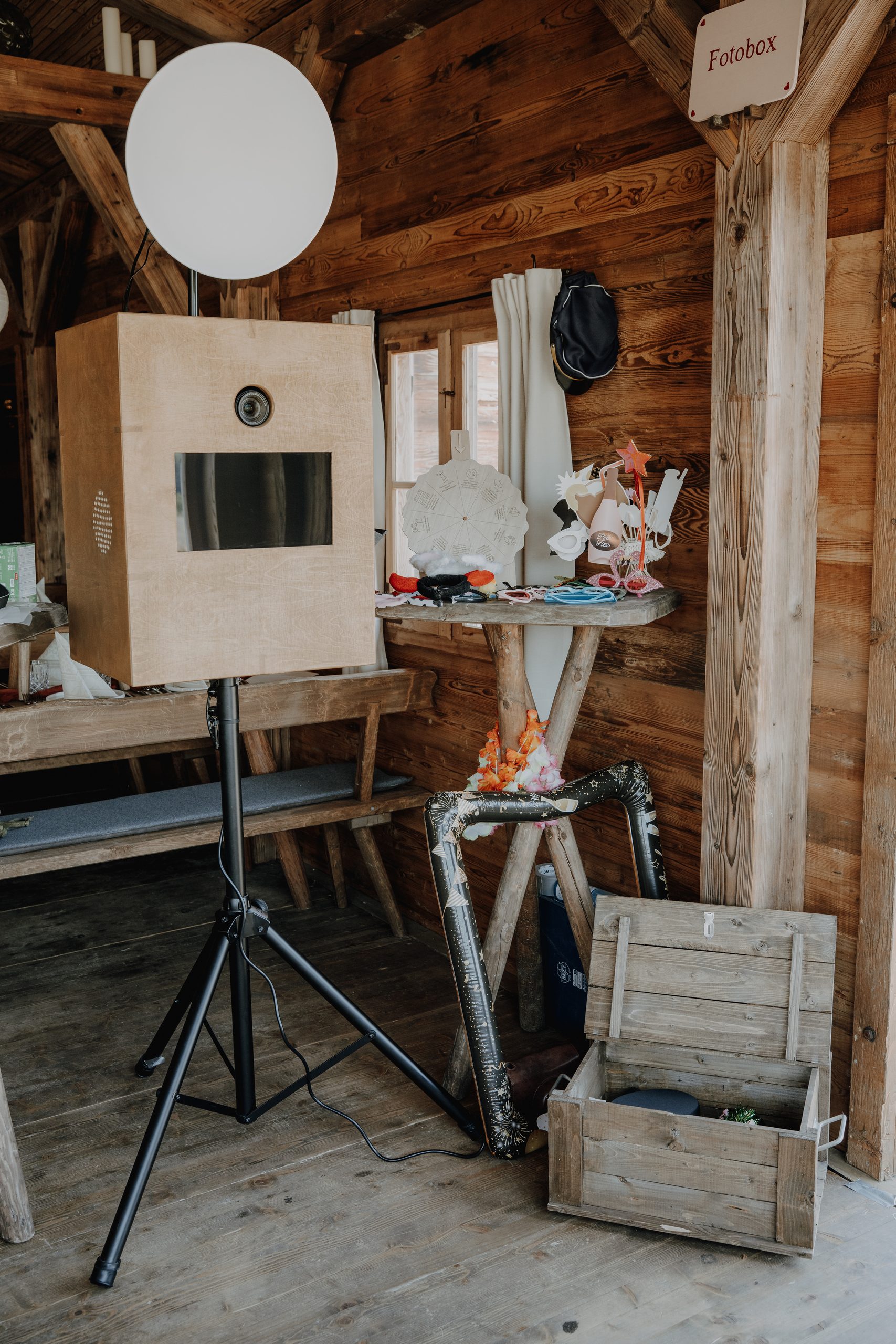 Fotobox mit Touchscreen und Requisitentisch in einer Holzhütte